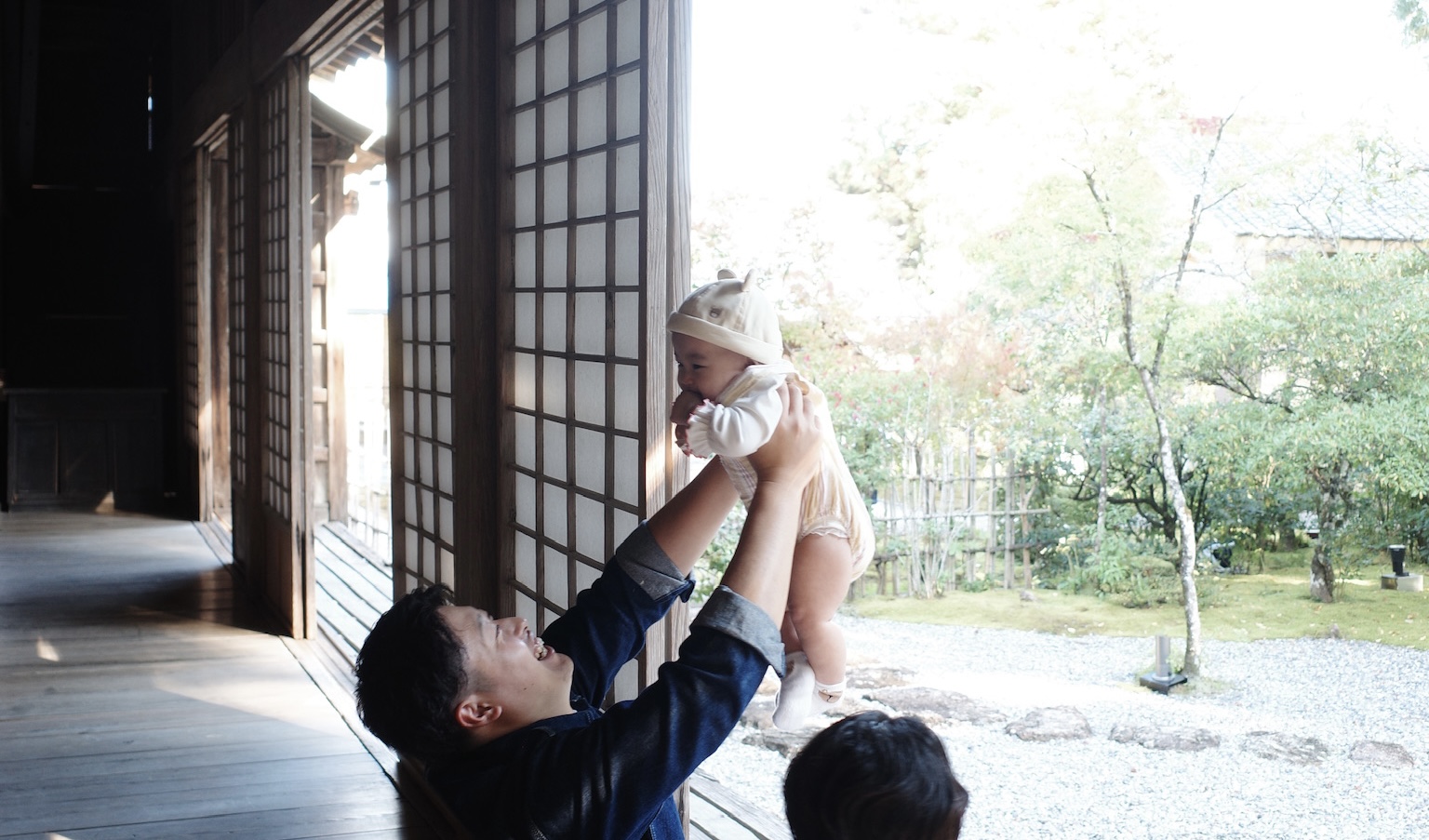 子どもを抱き上げている三代木行員